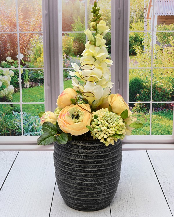 Black with white wash finished container with Snapdragons and Ranunculus.